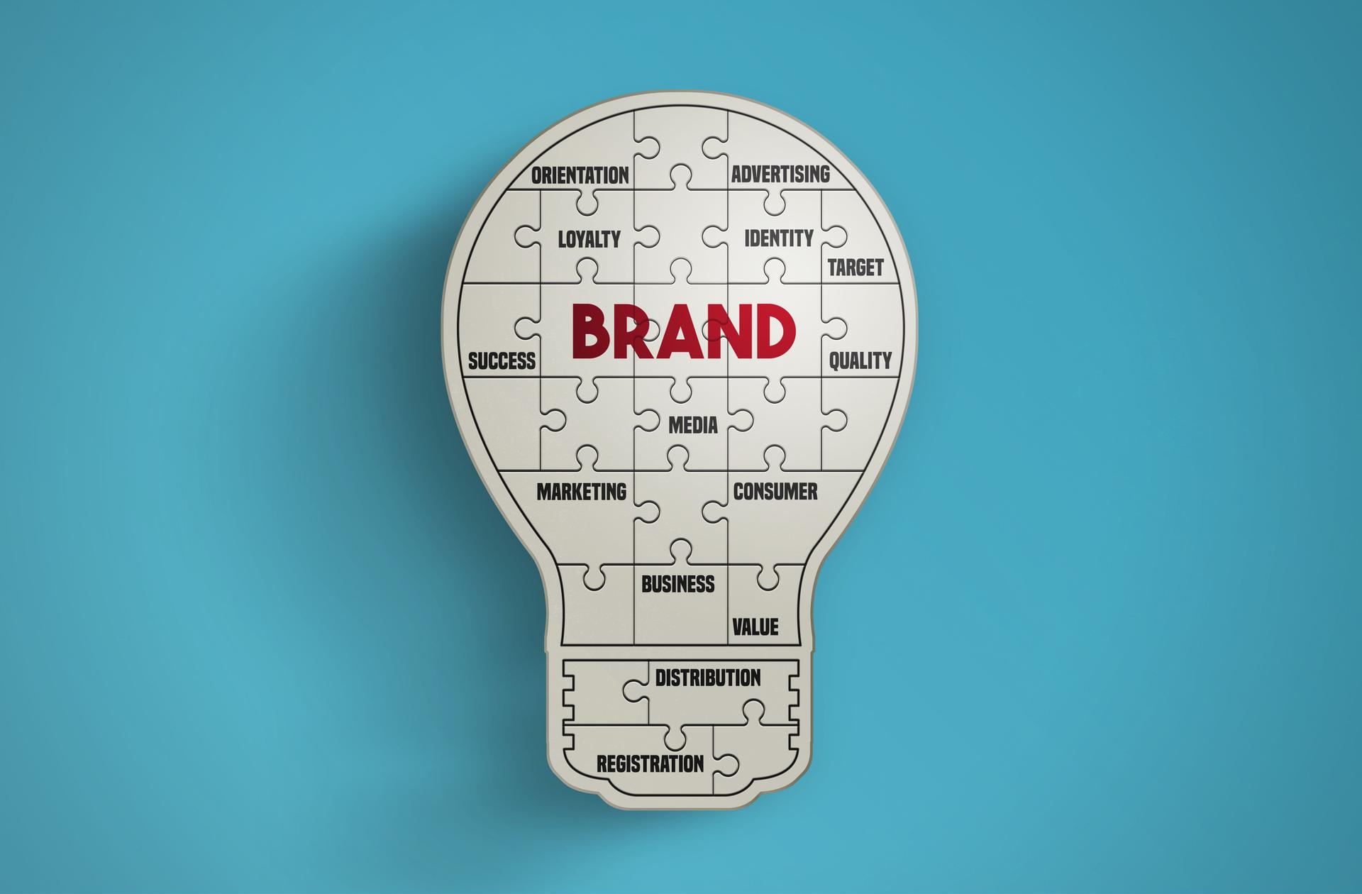 Light bulb puzzle pieces forming the word Brand on blue background.